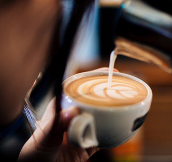 Latte Art Motiv wird in Cappuccino Tasse gegossen 