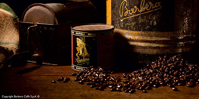 Kaffeebohnen auf dunkler Holzplatte mit Fässern im Hintergrund