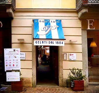 Italienisches Gebäude von Caffe Vergnano mit blau-weiß gestreiften Vordach