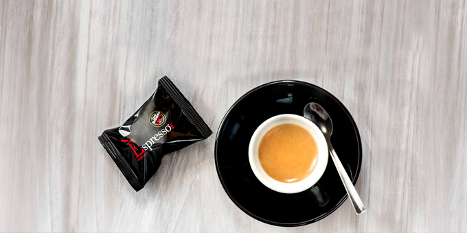 Ein Vergnano Kaffeekeks passend im schwarzen Design neben der Espressotasse