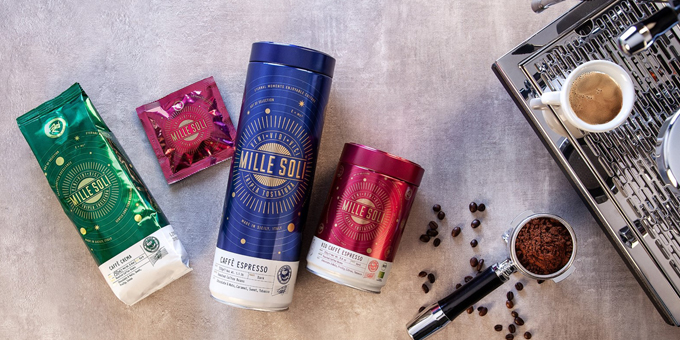 Produkte von Mille Soli auf grauem Hintergrund, daneben ein befüllter Siebträger und ein paar Kaffeebohnen