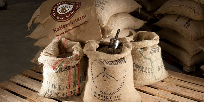 Braune Kaffeesäcke von De Koffiemann gestapelt auf Europaletten