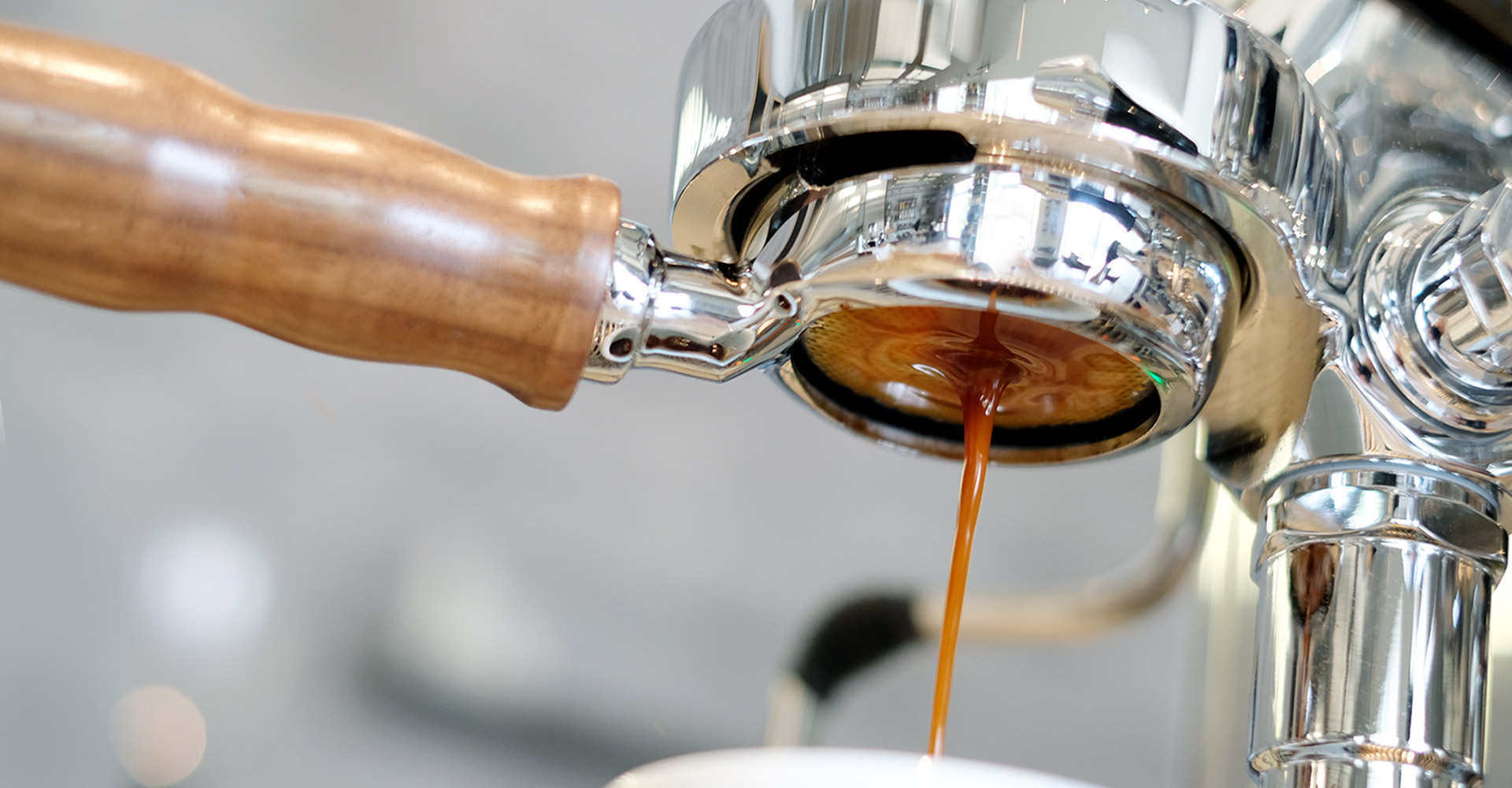 Kaffee läuft aus einer Kaffeemaschine in eine Tasse