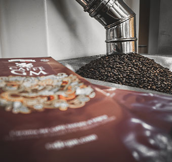 GM Caffé Verpackung mit Kaffeebohnen im Hintergrund