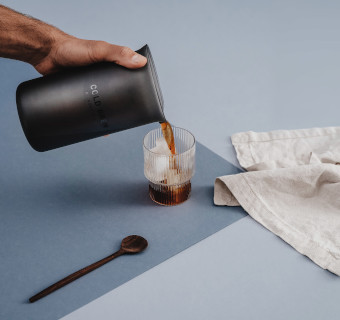 Ein Cold Brew Bereiter kippt Kaffee in ein Glas